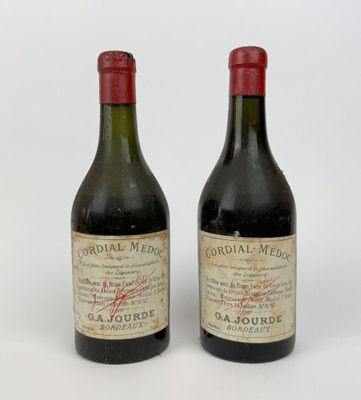 deux bouteilles de vin rouge posées l'une à côté de l'autre sur une surface blanche