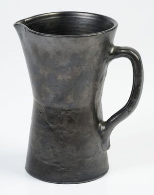 a black pitcher that is sitting on a white surface