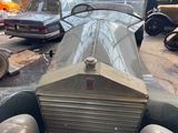 an old car that is parked in a parking lot