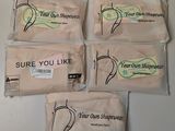 four bags of soap sitting on top of a white counter
