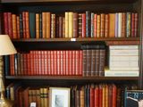 une chaise rouge devant une bibliothèque remplie de livres