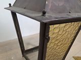 an old fashioned lantern with a metal frame on a wooden floor