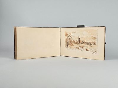 an open book sitting on top of a table next to a white wall