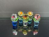 cinq vases remplis de fleurs posés sur une table