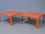 une paire de tables d'appoint en plastique orange sur fond gris