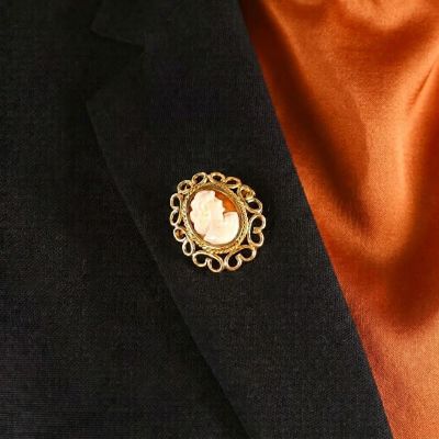 un gros plan d'une personne portant un costume et une cravate, avec une broche