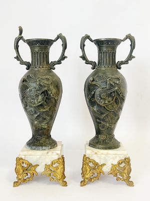 paire de vases anciens en bronze sur des socles en marbre, ornés de poignées en forme de lion