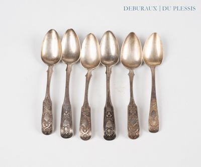 six silver spoons are lined up in a row on a white surface