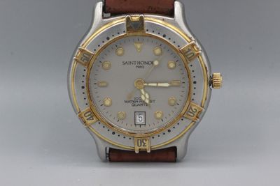 une montre en argent et en or avec un bracelet en cuir marron