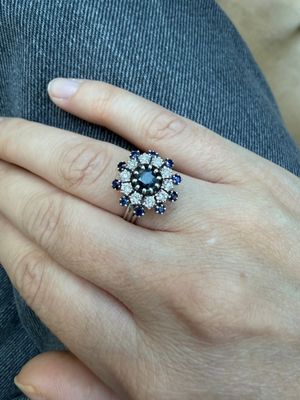 la main d'une femme portant une bague ornée d'un motif floral