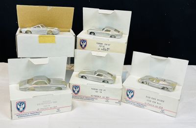 quatre boîtes de petites voitures posées sur une table blanche