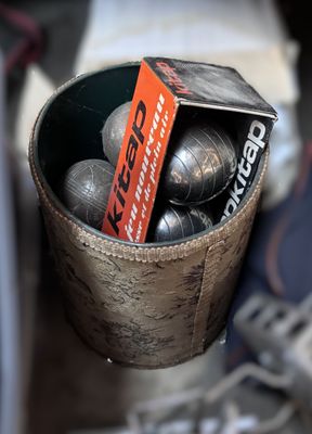 a bucket full of metal balls with a tag in it