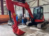 a red excavator that is parked in a building