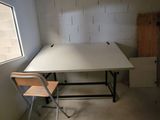 une table et une chaise blanches dans une pièce dotée d'une fenêtre