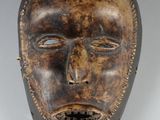 gros plan d'un masque en bois sur une surface blanche