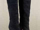 black sued high heel boots on a wooden floor