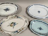 quatre assiettes posées sur la table, ornées de fleurs bleues