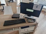 a desk with a keyboard, mouse and monitor on it