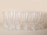 six empty wine glasses lined up on a table