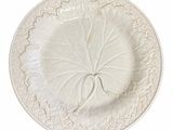 une assiette blanche ornée d'une feuille sur fond blanc