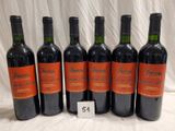 six bottles of red wine are lined up on a table