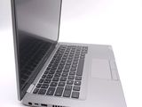 a silver laptop with a black keyboard on a white surface
