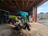 un tracteur garé dans un garage à côté d'un bulldozer