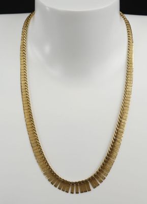 un collier plaqué or sur un mannequin