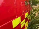 a red van with yellow and red stripes parked in the grass
