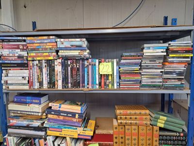 de nombreux livres empilés sur une étagère dans une pièce