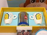 a box with two coffee cups and a can of tea