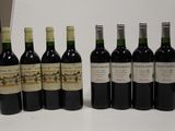 six bottles of wine are lined up on a table