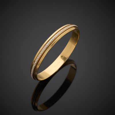 a gold wedding ring with diamonds on a black surface