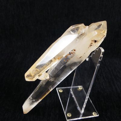 un cristal de quartz transparent posé sur un socle en acrylique transparent