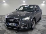 L'Audi QX est garée sur un sol à damier dans un garage.