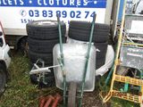 a pile of tires and a wheelbarrow in front of a truck