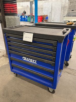 un gros plan d'une boîte à outils bleue sur roulettes dans un garage