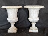 pair of antique cast iron urns on a black background