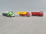 three toy trucks sitting side by side on a table
