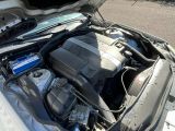 un moteur de voiture dont le capot est ouvert, garé dans la rue