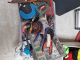 une valise remplie d'outils et un skateboard posé par terre