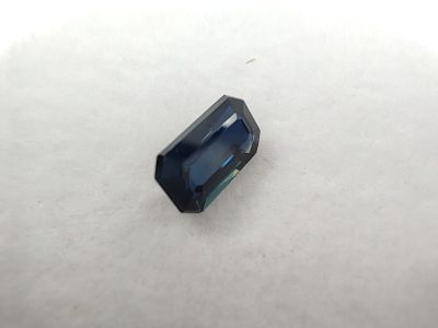 un saphir bleu posé sur une surface blanche