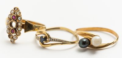 deux bagues en or ornées de perles et de grenats sur un fond blanc