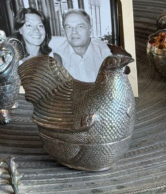 a photo of a man and a woman sitting next to a silver chicken