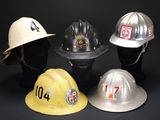 four fire hats are lined up in a row on a black background