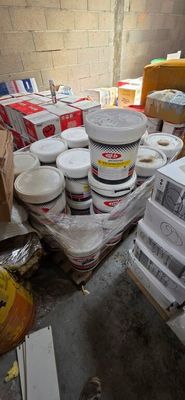 une pile de cartons et de pots de peinture par terre