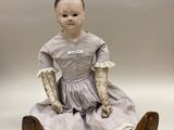une petite poupée assise par terre