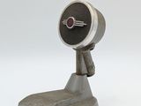 un petit objet métallique posé sur une surface blanche