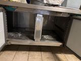 a stainless steel counter in a kitchen with a trash can