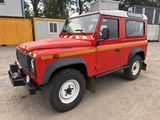 une photo d'un Land Rover rouge garé sur un parking